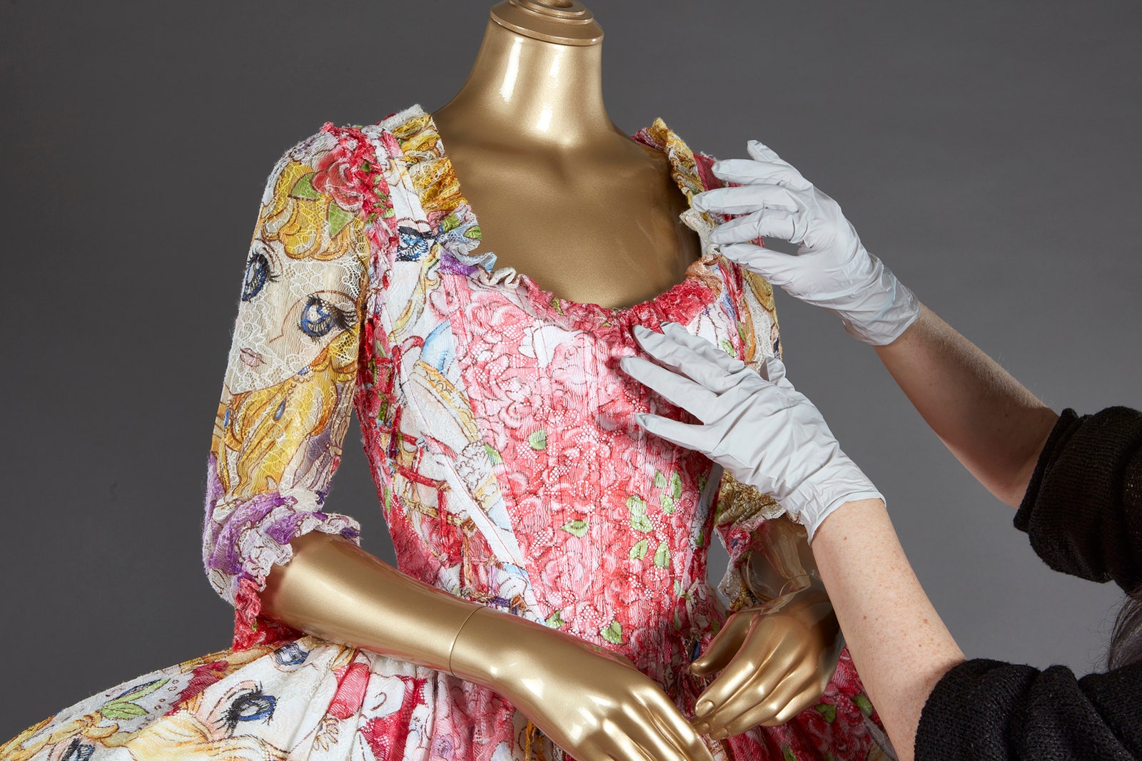 Beatrice Farmer'ın eli, Moschino Hazır Giyim Sonbahar 2020 Koleksiyonundan mini bir mantua elbiseyi düzeltiyor