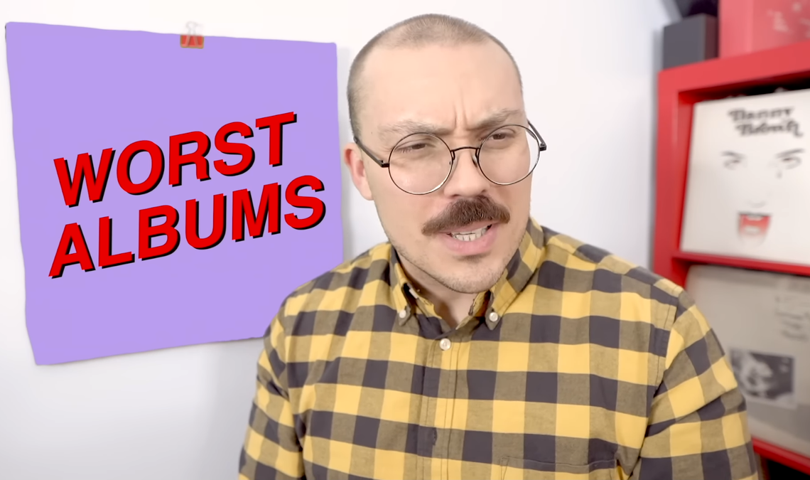 Anthony Fantano looks quizzical in front of a square reading