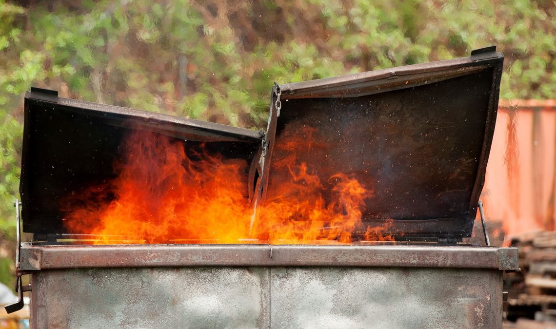 A photograph of a burning dumpster.